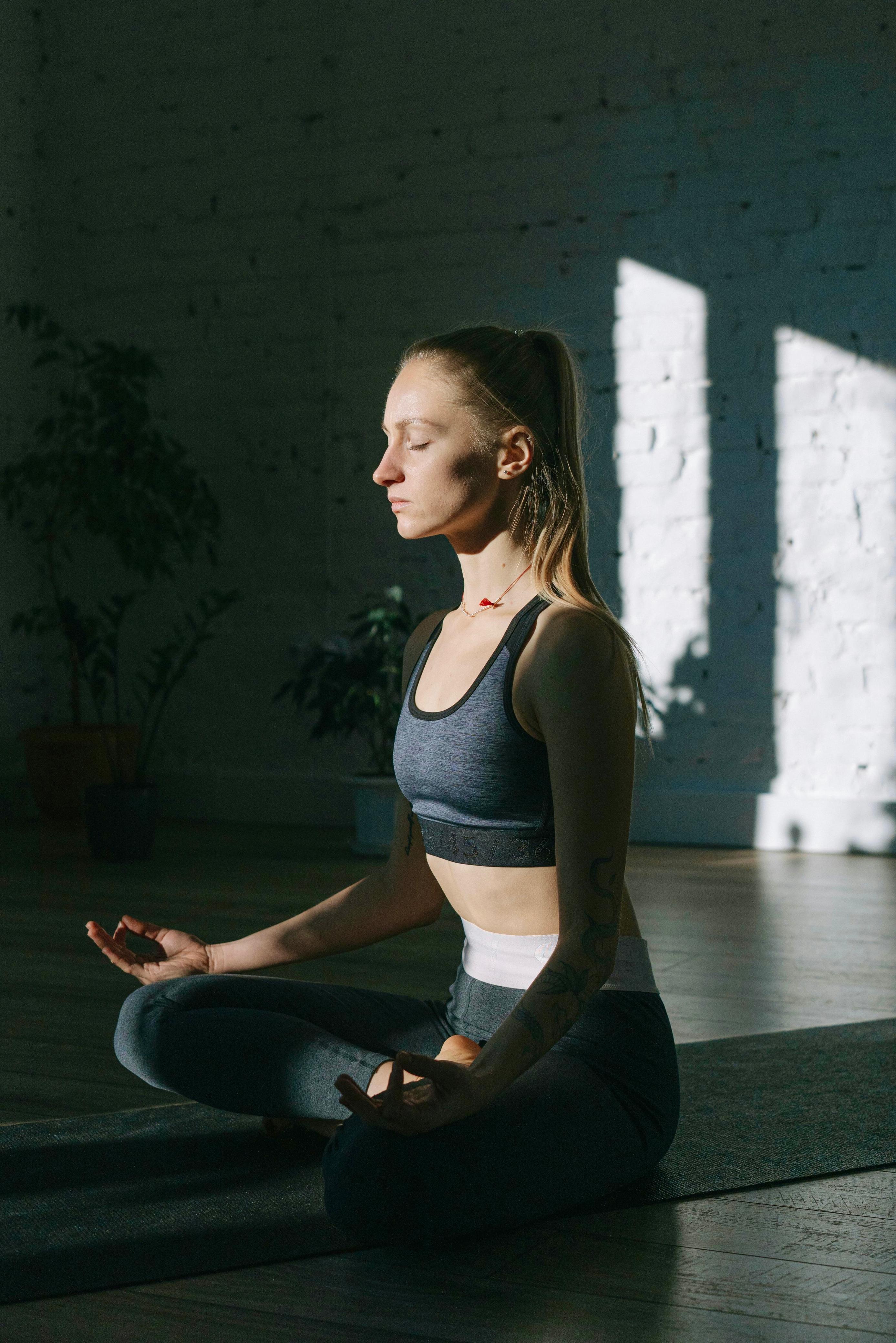 Woman meditating in sunlit studio